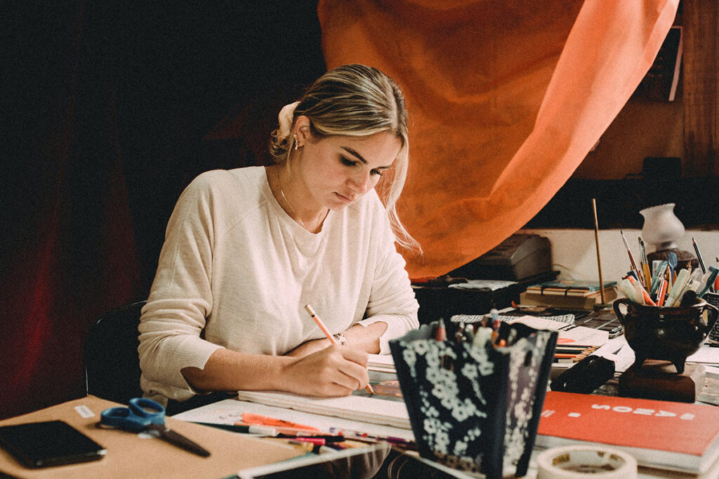 Woman writing with a pencil on her desk