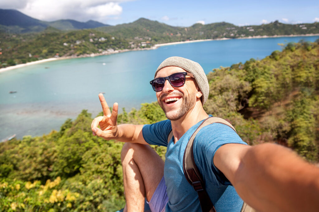 Man taking a selfie with the sea on the background